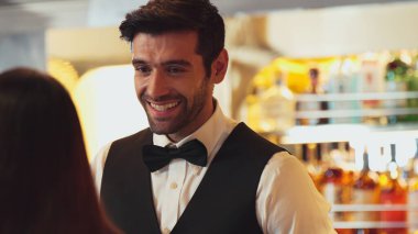 Gülümseyen zeki barmen, gece kulübünde VIP müşterilerle canlı sohbetler yapmak için güzel bir gece partisi atmosferine mükemmel bir servis sunuyor. Vinosity.