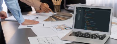 İç mimar tasarımcı grubu, daha kesin tasarım için planlar ve dizüstü bilgisayar ekran mimari yazılımı üzerinde birlikte tartışıyorlar. Modern ev tasarımı ve yenileme. İçgörü