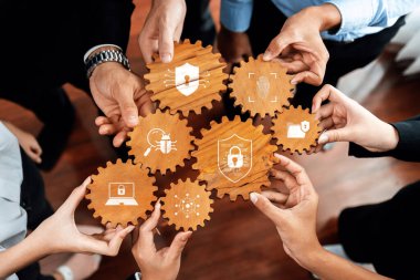 Çağdaş zorluklar için siber güvenlik, koruma ve dijital güvenlik çözümlerinde takım çalışmalarını gösteren, güvenlik sembolleriyle ahşap dişlileri tutan çeşitli bireylerden oluşan bir grup. Dostluk