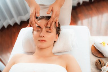 Kafkasyalı kadın stres önleyici kafa masajından ve lüks tatil beldesi ya da otel spa salonundaki modern ışık ortamında yüz güzelliği eğlencelerini şımartmaktan hoşlanıyor. Sessiz.