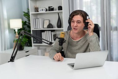 Sunucu kanalı, gülümseyen akıllı yayıncı kaydı, senaryosu ve akıllı telefonuyla sosyal medyada sohbet programı, kulaklık takarak modern ev stüdyosundaki video flamalarını kaydediyor. Bireysel.