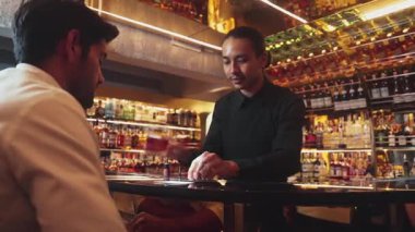 Barmen klasik viski bardağı servisi yapıyor. Cuma gecesi arkadaşlarla yapılan lüks içki barında akıllı bir konukla özel bir hoş geldin partisi öneriyor. Vinosity.