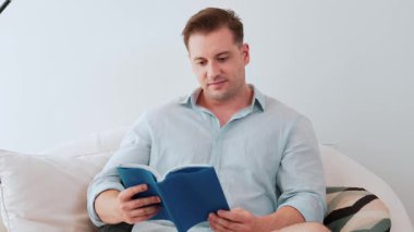 Kanepede oturan orta yaşlı bir adam, sosyal ve teknolojik mesleki gelişmeler hakkında ders kitabı okur ya da çocukları iyi bir yetişkin baba olmak için yetiştirir. Hayat boyu öğrenme konsepti. Uyumsuzluk.