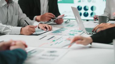 Dinamik bir iş ekibi, modern ofis ortamında tablet ve ekranlar üzerindeki çizelge ve grafikleri analiz ederek stratejik planlamalara odaklanıyor. SACTR