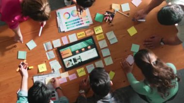 Web tasarımı için birlikte çalışan iş adamlarının üst düzey görüşü. Tasarımcı beyin fırtınası yapan ve web sitesi arayüzü hakkında tartışan ve dijital tasarım ile tablete bakan hava görüşü. Sempozyum.