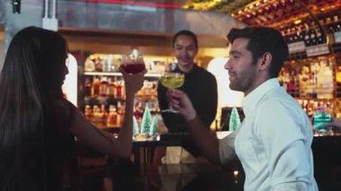 Özel Midori Sour ve punç kokteyli içen grup arkadaşının şerefine Noel ağacı neon kar festivali temalı lüks tezgah barında şeker kamışlı kokteyl, sıcak dostluk gece hayatı. Vinosity.