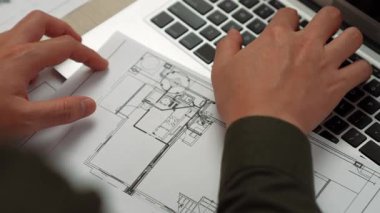 Mimari ya da mühendis, modern ofiste doğruluk için mimari belgeye veriler yazıp, dizüstü bilgisayarda ayrıntılı tasarım planı olan bir yapı tasarlıyor. - Yakın çekim. Tanımlama.