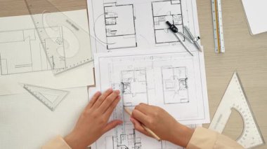 Akıllı mimar ya da akıllı mühendisin ölçüm aracı ve kalem el kullanarak mimari ofisindeki inşaat isabet planı üzerine detaylı bir yazı yazışının videosu. Eline odaklan. - Yakın çekim. Tanımlama.
