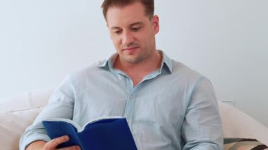 Kanepede oturan orta yaşlı bir adam, sosyal ve teknolojik mesleki gelişmeler hakkında ders kitabı okur ya da çocukları iyi bir yetişkin baba olmak için yetiştirir. Hayat boyu öğrenme konsepti. Uyumsuzluk.