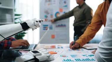 Profesyonel ve zeki asistanların iş raporlarını ve optimal sonuçlar için rafine stratejileri analiz ettikleri modern bir ofiste yapay zeka destekli işbirliği. Noogenesis Yapay Zeka