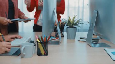 Çeşitli profesyonellerden oluşan bir grup, üretken beyin fırtınaları için teknoloji ve yaratıcı unsurlarla çevrili modern bir ofis çalışma alanında ortak bir toplantıya katılıyor. SACTR