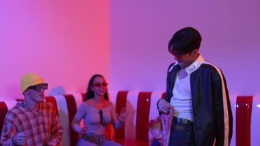 Asyalı bir adam pop müzikle dans ederken, çok kültürlü bir arkadaş evde ışık altında oturuyor. Çekici bir sokak dansçısı kameraya bakarken hip hop müzik dinliyor. Mutluluk.