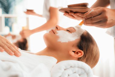 Kaplıca salonunun sakin atmosferi, modern gün ışığında lüks yüz kremi masajıyla gençleşmeye hevesli çiftler. Yüz bakımı ve güzellik konsepti. Sessiz.