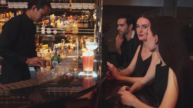 Barda oturmuş, Margarita kokteylinin tadını çıkartan ekşi bir içkinin tadını çıkaran bir çiftle sohbet ederken, kadınlar lüks tezgahın önünde, canlı bir gece kulübünde arkadaşlarını bekliyorlar. Vinosity.