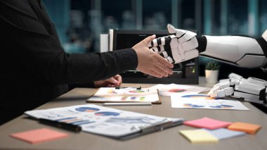 Bir insan ve bir robot, teknoloji ve iş analizlerinde işbirliğini ve yeniliği sembolize eden modern bir ofis içinde el sıkışırlar.