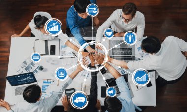 Üst düzey ofis çalışanları ofis odasında el ele tutuşarak iş sinerjisini ve iş yerindeki güçlü üretken takım çalışmasını sembolize ediyor. İş çalışanları arasındaki işbirliği ve birlik. İhtiyatlı Dostluk