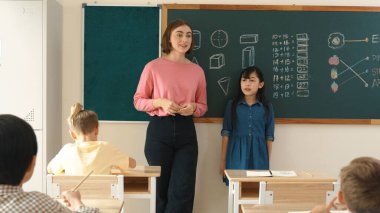 Asyalı kız sınıfın önünde kendinden emin bir şekilde yürürken beyaz bir öğretmen gönüllü istiyor. Zeki öğrenci, öğretmenler el çırparken elini kaldırdı ve soruyu cevapladı. Pedagoji.