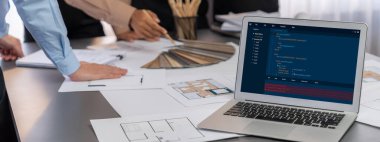 İç mimar tasarımcı grubu, daha kesin tasarım için planlar ve dizüstü bilgisayar ekran mimari yazılımı üzerinde birlikte tartışıyorlar. Modern ev tasarımı ve yenileme. İçgörü