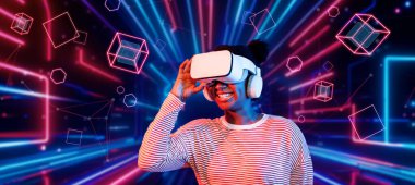 Çevresindeki geometrik şekle bakan kız metaevrende yüzüyor. Sanal dünyaya erişen mutlu genç ya da oyuncu VR kulaklık ve artırılmış gerçeklik teknolojisi kullanıyor. Teknoloji yeniliği. Yaratıcılık.