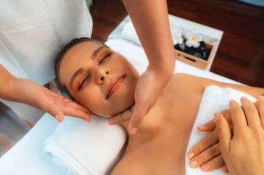 Kafkasyalı kadın stres önleyici kafa masajından ve lüks tatil beldesi ya da otel spa salonundaki modern ışık ortamında yüz güzelliği eğlencelerini şımartmaktan hoşlanıyor. Sessiz.