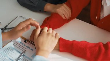 Çift, hastanede jinekoloğun doğum veya tıbbi danışmanlığına, doktor ve koca genç eşi randevuyla teselli ederken aile planlamasına katılıyor. Ağır çekim. Katı.