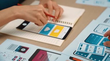 Mobil uygulama için kullanıcı arayüzü prototipi ya da masadaki program modeliyle birlikte web sitesi planlaması yapan bir şirket çalışanı. UX UI tasarımcısı kullanıcı dostu arayüz planını dikkate alır. Sinerjik