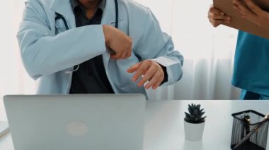 Hastane masasında birlikte çalışan ve tıbbi tedavi planlayan çeşitli profesyonel sağlık görevlileri. Takım çalışması başarılı hastalıklara ve hastalıklara yol açar. Ağır çekim. Katı.