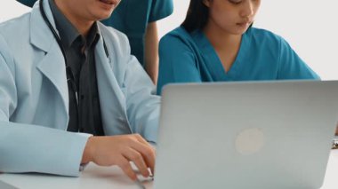 Hastane masasında birlikte çalışan ve tıbbi tedavi planlayan çeşitli profesyonel sağlık görevlileri. Takım çalışması başarılı hastalıklara ve hastalıklara yol açar. Ağır çekim. Katı.