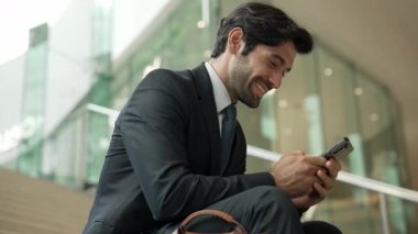 Başarılı bir iş adamı merdivenlerde otururken başarılı bir projeyi kutluyor. Akıllı proje yöneticisi yeni bir iş buluyor, terfi alıyor, telefonla arkadaşlarını ararken satışları arttırıyor. Sevinçli..