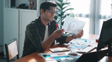 Toplantıda profesyonel tasarımcı yazma ve logo grafiği tasarlama. Renkli paletler üzerinde çalışan iş adamlarının yakınlaşması ve masaya kağıt ve ekipman ile yapışkan notlar yazmak. Sempozyum.