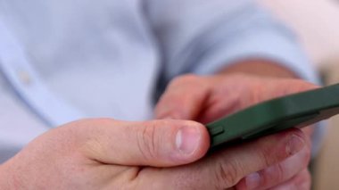 Orta yaşlı bir adam oturma odasındaki koltukta oturur telefon arama verilerini kullanır çocukları iyi bir yetişkin baba ya da eğlence olarak yetiştirir. İşadamı teknolojiyi kolaylık için kullanır. Uyumsuzluk.