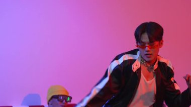 Çekici Asyalı sokak dansçısı neon ışıkla serbest stil hareketi yapıyor. Profesyonel sanatçı, çeşitli arkadaşlarıyla ya da stüdyoda ışık saçan bir ekiple hip hop müzik yapmaya çalışıyor. Mutluluk.
