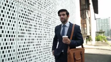 İş adamı telefona cevap verir ve iş yatırımları hakkında konuşur. İş planı, pazarlama stratejisi ya da çalışma hakkında konuşmak için akıllı telefonla konuşurken sokakta yürüyen mutlu bir yönetici. Sevinçli..