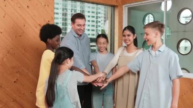 Kafkas öğretmeni ve çeşitli çocuklar sınıfta ayakta dururken başarılı projeyi kutlamak için el ele tutuşuyorlar. Aşkı, takım çalışmasını, güveni, birlikteliği ve birliği temsil et. Öğretim