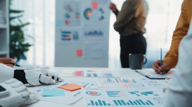 Yüksek teknolojili bir ofiste, danışman, etkili pazarlama stratejileri sağlamak ve iş planlamasını düzene sokmak için yapay zeka kavrayışından yararlanır. Noogenesis Yapay Zeka