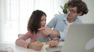 Mutlu akıllı baba, kızına mühendislik komut veya kod yazmayı öğretirken kalemini gösterip kulağına takıyor. Kafkasyalı baba programlama sistemini ya da genç liseli kızlara yapay zeka üretmeyi açıklıyor. Pedagoji.