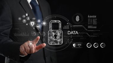 Bir işadamı, ileri teknoloji ortamda veri koruması ve siber güvenlik kavramlarını gösteren gelecekteki dijital güvenlik arayüzü ile etkileşime geçiyor. XDMCP