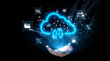 Yükleme ve indirmeyi sembolize eden parlayan bir bulut simgesini tutan bir elin dijital temsili. Çevreleyen ikonlar çeşitli bulut hizmetleri ve teknoloji kavramlarını gösteriyor. Dörtgen