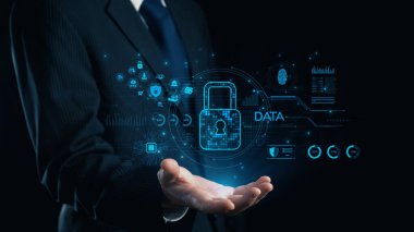 Takım elbiseli bir işadamı, veri güvenliğini simgeleyen parıldayan dijital bir kilit taşıyor. Fütüristik arka planda modern siber güvenlik temalarını gösteren çeşitli teknoloji simgeleri yer alıyor. Dörtgen