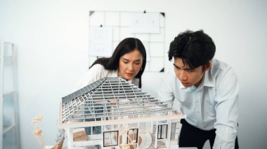 Modern ofisteki ev modeli yapısını kontrol etmeye odaklanan genç, profesyonel mimar mühendis ekibine yakın çekim. Yaratıcı profesyonel tasarım ve takım çalışması konsepti. Tertemiz..