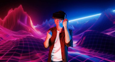 VR kulaklık takan ve soyut arka planda duran sıradan giysili bir adam video oyunu oynuyor. Zeki Asyalı oyuncu oyunu kazanmak için artırılmış gerçeklik teknolojisini kullanıyor. Yaratıcılık.