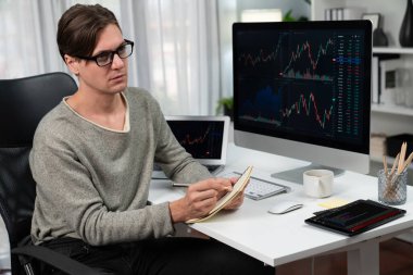 Gündelik işlerde çalışan zeki bir tüccar, dinamik yükseltilmiş borsa grafiğinin kar değerini analiz ederek, modern ofisteki kârlı yatırım listesi için kağıt üzerinde not alıyor. Bireysel.