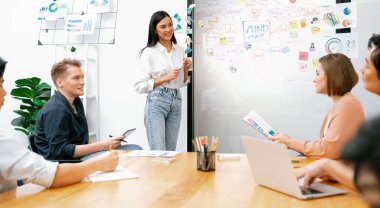 Genç ve güzel lider pazarlama stratejisini sunarken, uzman yatırımcı ve proje yöneticisi de yeni başlayan iş toplantısında iş performansını analiz etmeye çalışıyor. Çok ırklı bir grup. Tertemiz..