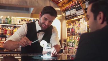 Akıllı barmen, lüks bir tezgahta arkadaşını beklerken limonlu cin kokteyli ikram ediyor. Barmen, canlı gece hayatı parti atmosferinde mükemmel hizmet veriyor. Vinosity.