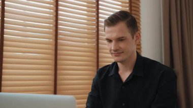 Genç adam internet bankacılığı için kredi kartlı dizüstü bilgisayar kullanıyor. İnternet üzerinden alışveriş yapıyor. Banka kartıyla modern ve kullanışlı online satın alma. Düzenle