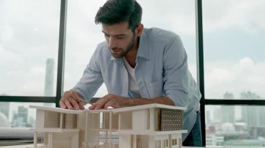 Akıllı inşaat mühendisi ev modelini ve taslağı ölçüyor. Profesyonel mimar ölçümü, panorama penceresinin yanında gökdelen ile dururken tasarım evi modeli. İzleme