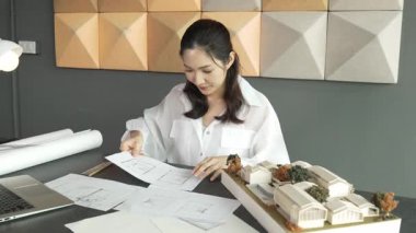 Genç, güzel mimar mühendisinin kalemle ölçüm yaptığı yere yakın çekim. İç mimar, tasarım evinin yapısını kalemle işaret ediyor. İş tasarımı konsepti. Geçmişi bulanıklaştırıyor. Yönlendirici.