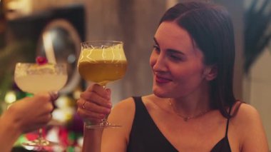 Güzel bir kadın, elinde bir bardak hindistan cevizli, köpüksüz içecek olan bir arkadaşıyla karışık çarkıfelek meyveli kokteyli hazırlıyor. Gece kulübü tezgahı partisinde canlı bir sohbete girişiyor. Vinosity.