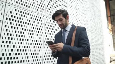 Akıllı iş adamı iş yatırımları hakkında konuşmak için telefonu kullanıyor. İş planı, pazarlama stratejisi ya da çalışma hakkında konuşmak için akıllı telefonla konuşurken sokakta yürüyen mutlu bir yönetici. Sevinçli..