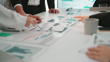 İş adamları stratejik tartışmalara girerken, analitik çizelge ve grafikleri gözden geçirir, modern bir ofis çalışma alanında işbirliğini ve yenilikçi çözümleri teşvik eder. SACTR